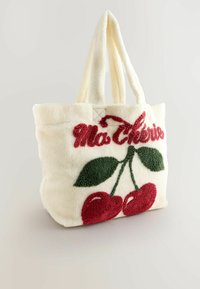 Tote bag lavet af creme-fleece, dekoreret med røde kirsebær og grønne blade med "Mon Chéri" broderet i rødt. To stofhåndtag.