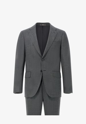 Pilkas raštuotas kostiumas, turintis dviejų mygtukų švarką su įpjovomis apykaklėmis, priekinių kišenių, ir atitinkančiomis kelnių, pagamintas iš tekstūruoto audinio.