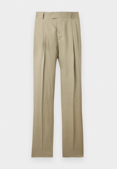 Μπεζ, ραμμένο κατά παραγγελία παντελόνι με πιέτες στο μπροστινό μέρος, θηλιές για ζώνη και ίσια γραμμή παντελονιού, σε μονόχρωμο φόντο.