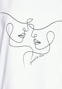 Camiseta blanca con un dibujo lineal minimalista en negro de dos rostros, con la inscripción "orgulloso de amar" mostrada debajo.