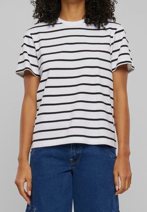 Person wearing a white short-sleeve shirt with black horizontal stripes and blue denim pants, standing against a plain gray background.