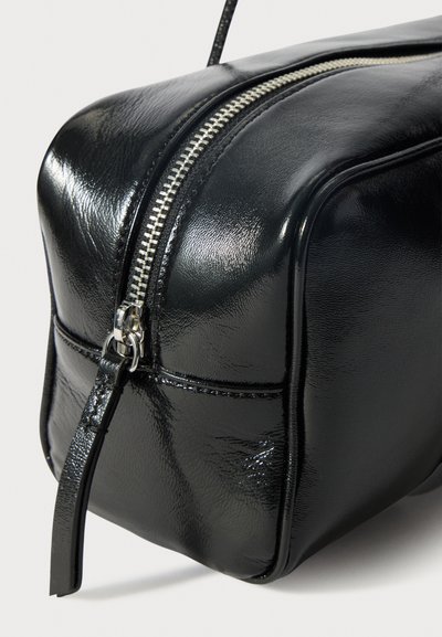 Borsa in pelle nera con finitura lucida, forma rettangolare, dettaglio della zip in argento e cuciture a contrasto lungo i bordi.