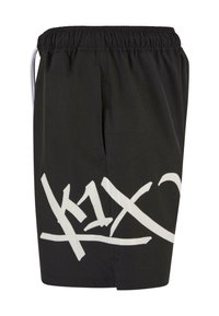 Sorte shorts med elastisk talje, med et stort hvidt grafikdesign på siden. Fremstillet af letvægtsmateriale med en glat tekstur.