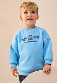 Lichtblauwe katoenen sweatshirt met een grafisch ontwerp van boerderijdieren en een tractor, ribgebreide manchetten en een ronde hals.