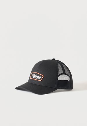 Casquette trucker noire en mesh avec visière incurvée et patch "Billabong Surf Goods" sur le panneau avant.