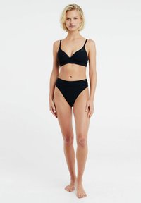 Set di bikini nero con un motivo testurizzato a righe. Il top ha un profondo scollo a V e spalline regolabili; il brasiliano a vita alta offre copertura totale.