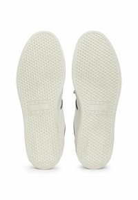 Fehér sneaker talpak texturált gumival, gyémánt mintázattal és a középen elhelyezett "TOMMY JEANS" felirattal.