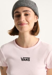 Rosa ribbed T-Shirt mit Rundhalsausschnitt und schwarzem "VANS"-Stickerei, kombiniert mit einer grauen Strickmütze. Einfaches und lässiges Design.