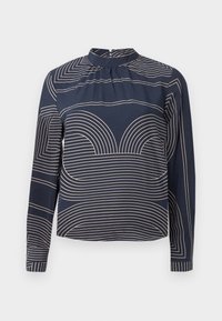 Langärmlige marineblaue Bluse mit hohem Kragen, die ein geometrisches cremefarbenes Streifenmuster und subtile Fältelungen an der Vorderseite aufweist.
