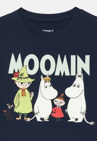 Tengerész kék pamut póló Moomin karakterek színes grafikával. A felirat "MOOMIN" betűi és részletes karakterábrázolások.