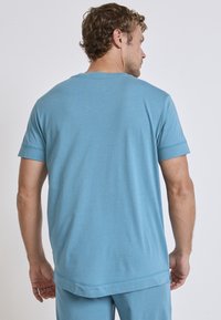 Blue cotton t-shirt with short sleeves, relaxed fit, flat seams, and a straight hem; featuring a soft texture and minimal design.