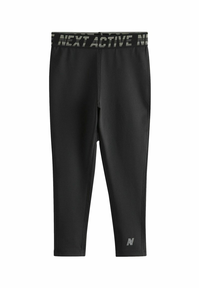 Zwarte sportleggingen met een brede, gemusterde tailleband met de tekst "NEXT ACTIVE" en een klein logo op het onderbeen aan de linkerkant. Glad, rekbaar materiaal.