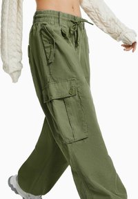 Olivegröna cargobyxor i mjukt tyg. De har ett dragsko-midjeband, sidofickor och en löst sittande design.