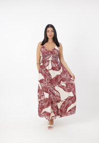 Robe maxi longue sans manches avec un décolleté en V profond, taille froncée et un motif de feuilles de palmier tropicales en bordeaux sur fond crème.