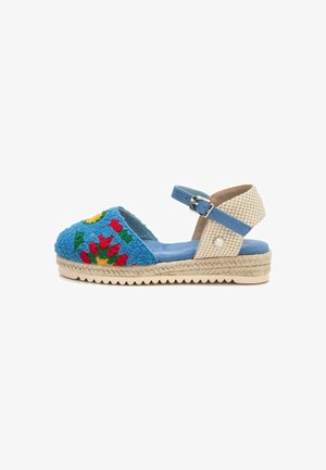 Espadrille azul bordado con patrones florales, correa al tobillo, suela de yute texturizada y diseño de plataforma. Acabado con un ribete azul claro.