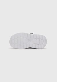 Semelle en caoutchouc blanche d'une sneaker avec des motifs de semelle rectangulaires et un petit logo Puma en relief au centre.