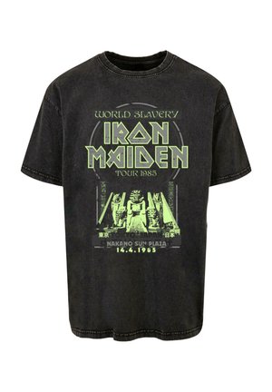 Čierne bavlnené tričko s moderným zeleným grafickým potlačou a textom, spojené s turné Iron Maiden v Japonsku v roku 1985.
