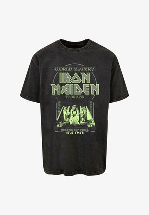Čierne bavlnené tričko s moderným zeleným grafickým potlačou a textom, spojené s turné Iron Maiden v Japonsku v roku 1985.