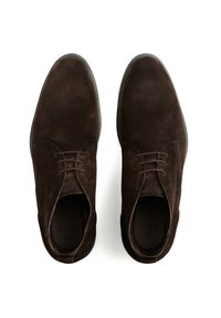 Scarpe stringate in suede marrone con finitura liscia, punta arrotondata e design minimale, dotate di suola piana in gomma e lacci coordinati.