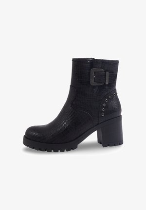 Bottines noires avec texture crocodile, bout rond, talon carré, accent de boucle sur le côté et rivets décoratifs près du talon.