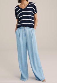 Marinblå och vit randig kortärmad V-ringad topp, matchad med ljusblå vida byxor med knäppning och veckad design.