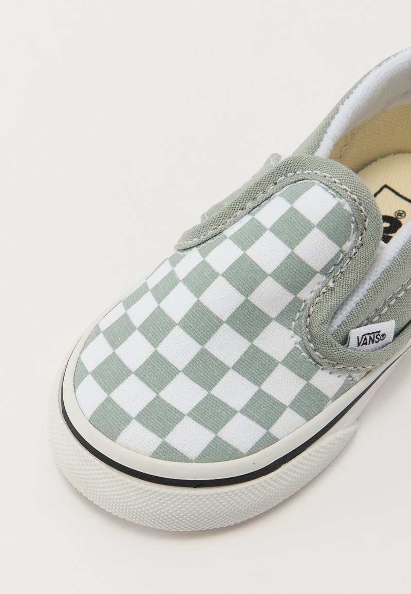 Groen-witte geruite instapschoen, van canvasmateriaal, met een ronde neus, witte rubberen zool met een gestructureerde grip, merklabel zichtbaar aan de zijkant.