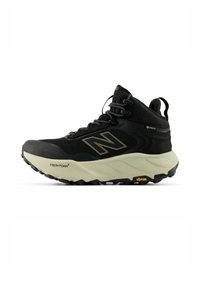 Zapato de senderismo negro con parte superior de malla, logo acentuado y suela Vibram. Cuenta con una suela acolchada y forro impermeable Gore-Tex.
