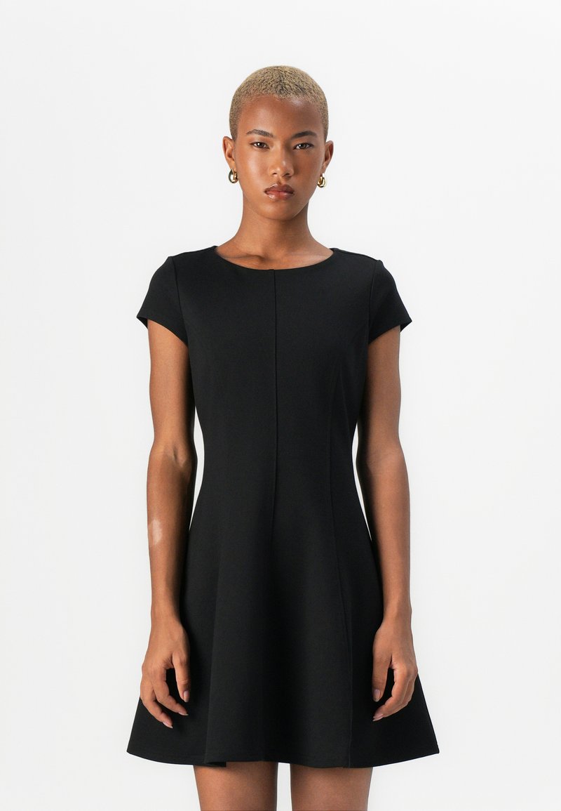Robe noire à manches courtes avec un col rond, corsage ajusté et jupe évasée. Fabriquée dans un tissu lisse avec des détails de couture subtils.