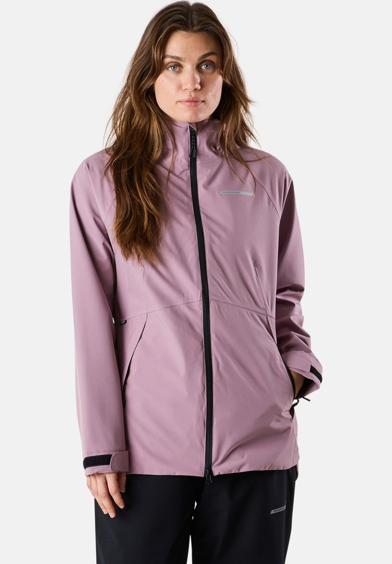 Veste imperméable en mauve clair, dotée d'un col montant, d'une fermeture éclair et de poches latérales. Rehaussée de finitions noires et de poignets élastiques.