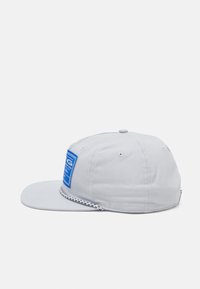 Gray baseball cap with a flat brim, featuring a blue rectangular logo patch on the front and a textured black-and-white stitched band.