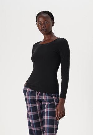 Black long-sleeve top with a scoop neckline, fitted design, and smooth texture, paired with plaid pants featuring blue and purple stripes.
