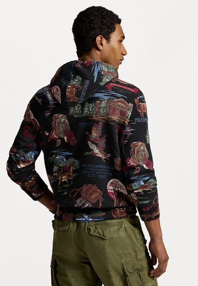 Hoodie van zwart stof met een meerkleurige print met een buiten-thema, waaronder dieren, hutten en logo's.