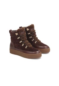 Botine din suede maro, cu un guler pufoș de culoare maro, dotate cu accesorii din metal auriu și talpă din cauciuc maro, în contrast, cu detalii texturate.