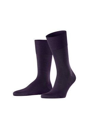 Ein Paar dunkelvioletter Socken bis zur Mitte der Wade mit gerippten Bündchen, auf einem weißen Hintergrund aufrecht präsentiert.