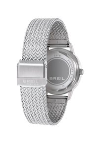 Montre en acier inoxydable argenté avec un bracelet en maille et un boîtier rond. Elle dispose d'une boucle polie et d'un cadran au design épuré et minimal.