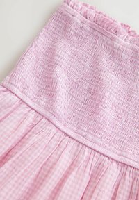 Roza shirna haljina s teksturiranim gornjim dijelom i nabranoj suknjom u gingham uzorku. Elastična čipka duž izreza.