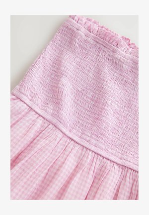 Rózsaszín, redőzött ruha, melynek texturált felső része és gyűrött szoknyája kockás mintázatú. Gumírozott fodros díszítéssel a nyakkivágásnál.