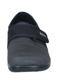 Black, fabric slip-on shoes featuring a textured upper, Velcro strap, and a solid rubber sole. Designed for comfort and ease of wear.