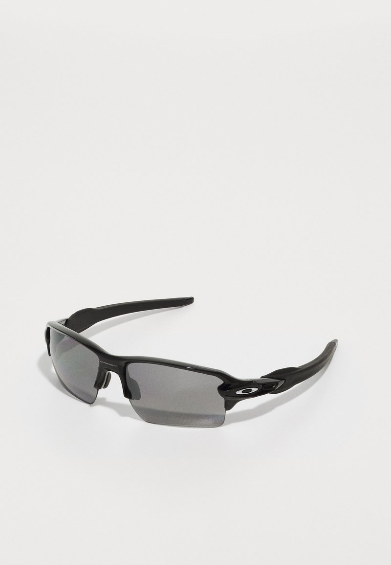 Óculos de sol desportivos pretos com lentes cinzentas, um design de armação curva e detalhe de logótipo na lateral. Feitos de material plástico leve.