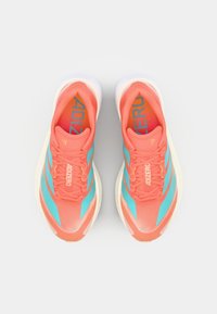 Korale i svijetloplave tenisice za trčanje s mrežastim gornjim dijelom, teksturiranim dizajnom i bijelom potplatom s "ADIZERO" logotipom na jeziku.