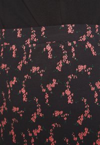 Tessuto floreale con uno sfondo scuro, caratterizzato da piccoli fiori rosa e foglie verdi. Texture morbida e design elasticizzato con una forma aderente.