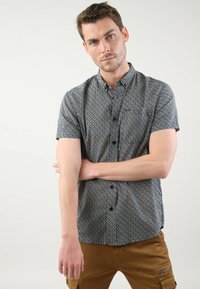 Korte mouw knoopshirt in donkerblauw met een geometrisch patroon, voorzien van een kraag, zwarte knopen en een slim fit ontwerp.