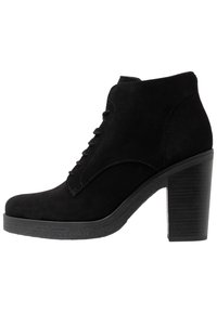 Botines de ante negro con puntera redonda, diseño con cordones y tacón apilado. Suela texturizada para agarre y estabilidad.