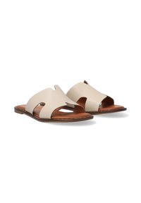 Beige leather sandals with open-toe design, cut-out detailing, flat brown sole, and smooth finish. Designed for comfort and breathability.