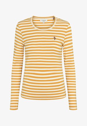 Kollane ja valge triibuline pika varrukaga särk, millel on ribakonstruktsioon ja ümmargune kaelus. Rinnaosa on kaunistatud väikese broderi logoga.