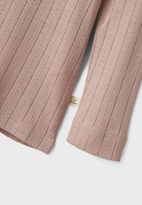 Roze ribgebreide trui met verticale strepen en kleine gaatjes. Heeft een textuur gebreide afwerking en een label aan de zoom.
