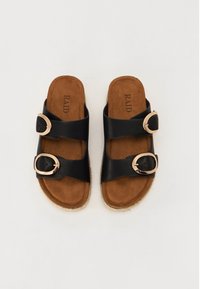 Schwarze Riemchensandalen mit zwei breiten Riemen und goldfarbenen Schnallen. Gepolsterter, brauner Fußbett mit einer Sohle im Espadrille-Stil aus Jute.