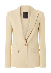 Blazer beige su misura con chiusura a un bottone, rever a punta, due tasche anteriori e una texture liscia. Progettato per una silhouette aderente.