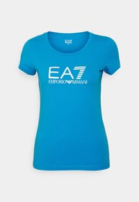 Modré tričko s krátkým rukávem a kulatým výstřihem; na přední straně uprostřed je potisk bílé logo "EA7 EMPORIO ARMANI". Hladká bavlněná tkanina.
