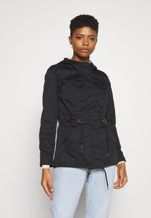 Veste noire avec capuche, taille à cordon de serrage et poches avant. Fabriquée dans un matériau doux et texturé, avec une fermeture éclair et des détails accentués.